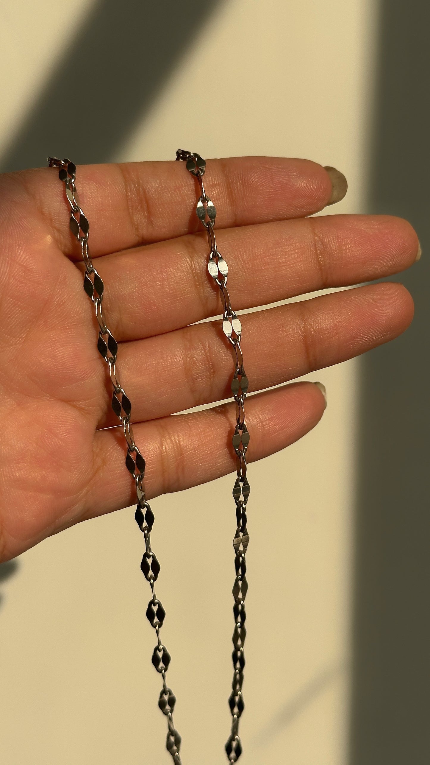 spark link chain close-up — faceted silver links catching the light