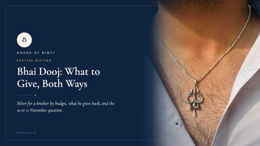 A silver band, a snake-chain bracelet and a trishul locket laid out beside a tika thali for Bhai Dooj