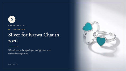 Silver toe rings, a thin payal and a small pendant on red cloth beside a sargi thali for Karwa Chauth 2026