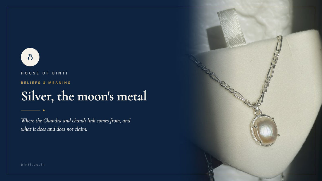 A silver pearl neckpiece lit from one side against deep navy, for a guide to silver and the moon in Indian belief