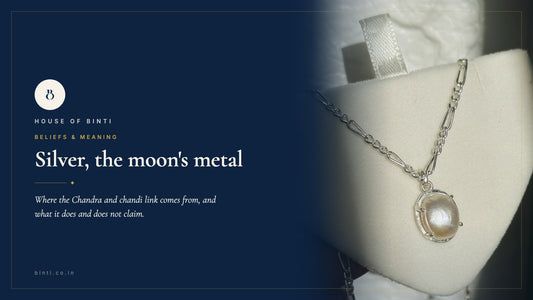 A silver pearl neckpiece lit from one side against deep navy, for a guide to silver and the moon in Indian belief
