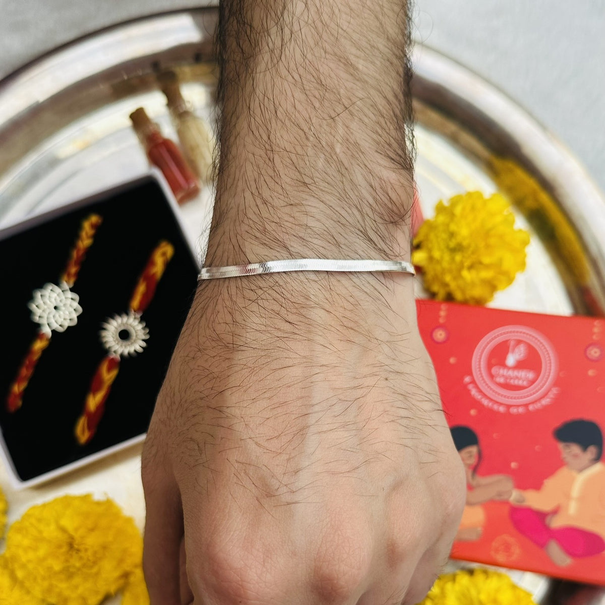 Man wearing a 925 sterling silver flat snake chain bracelet on his wrist