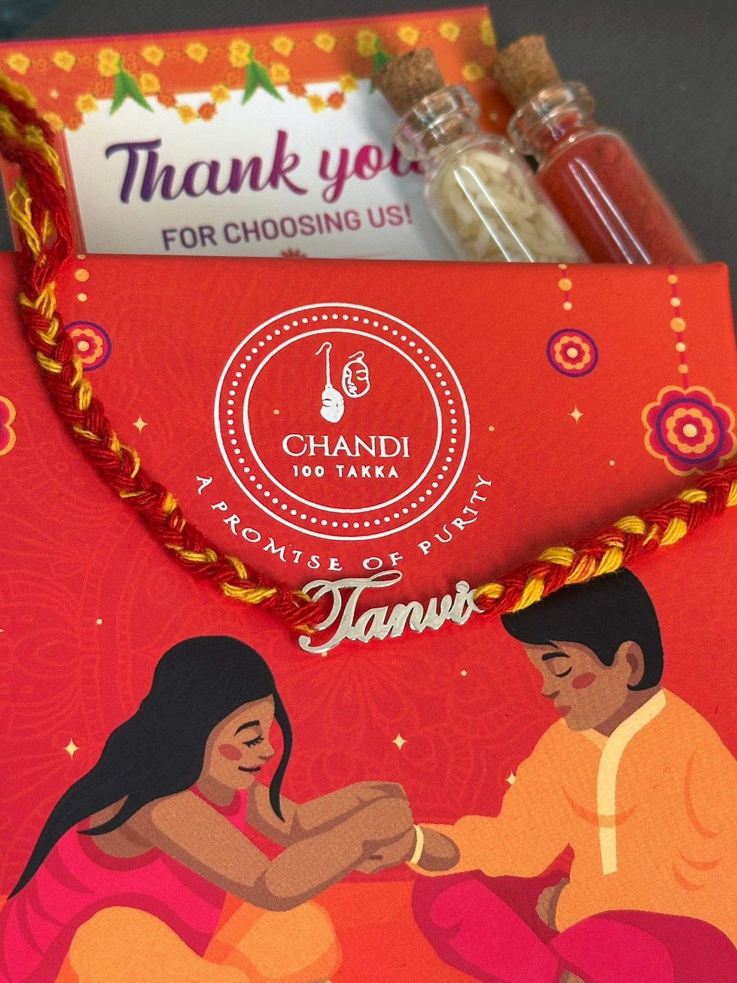 personalized name charm rakhi close-up — engraved silver name charm detail