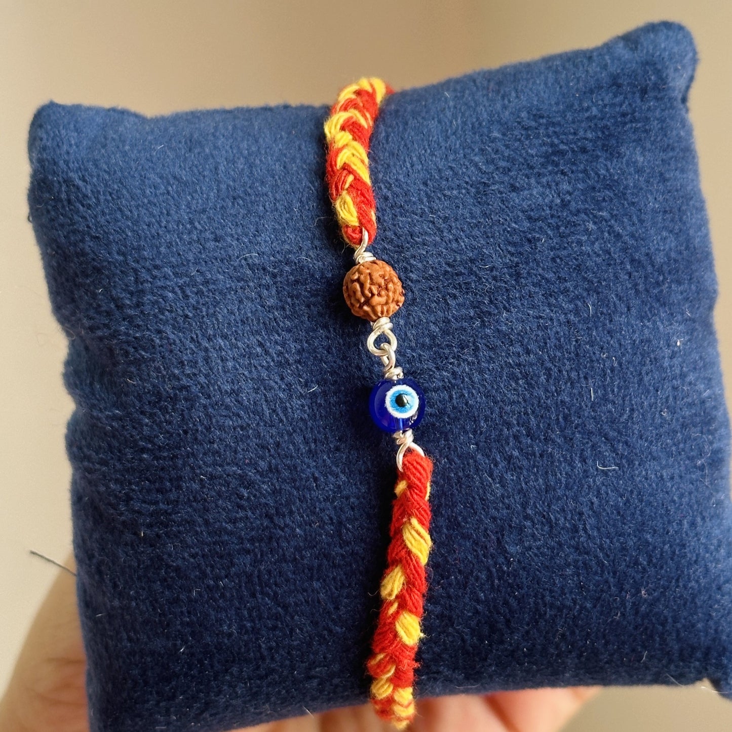 evil eye rudraksha rakhi close-up — blue nazariya bead and rudraksha detail