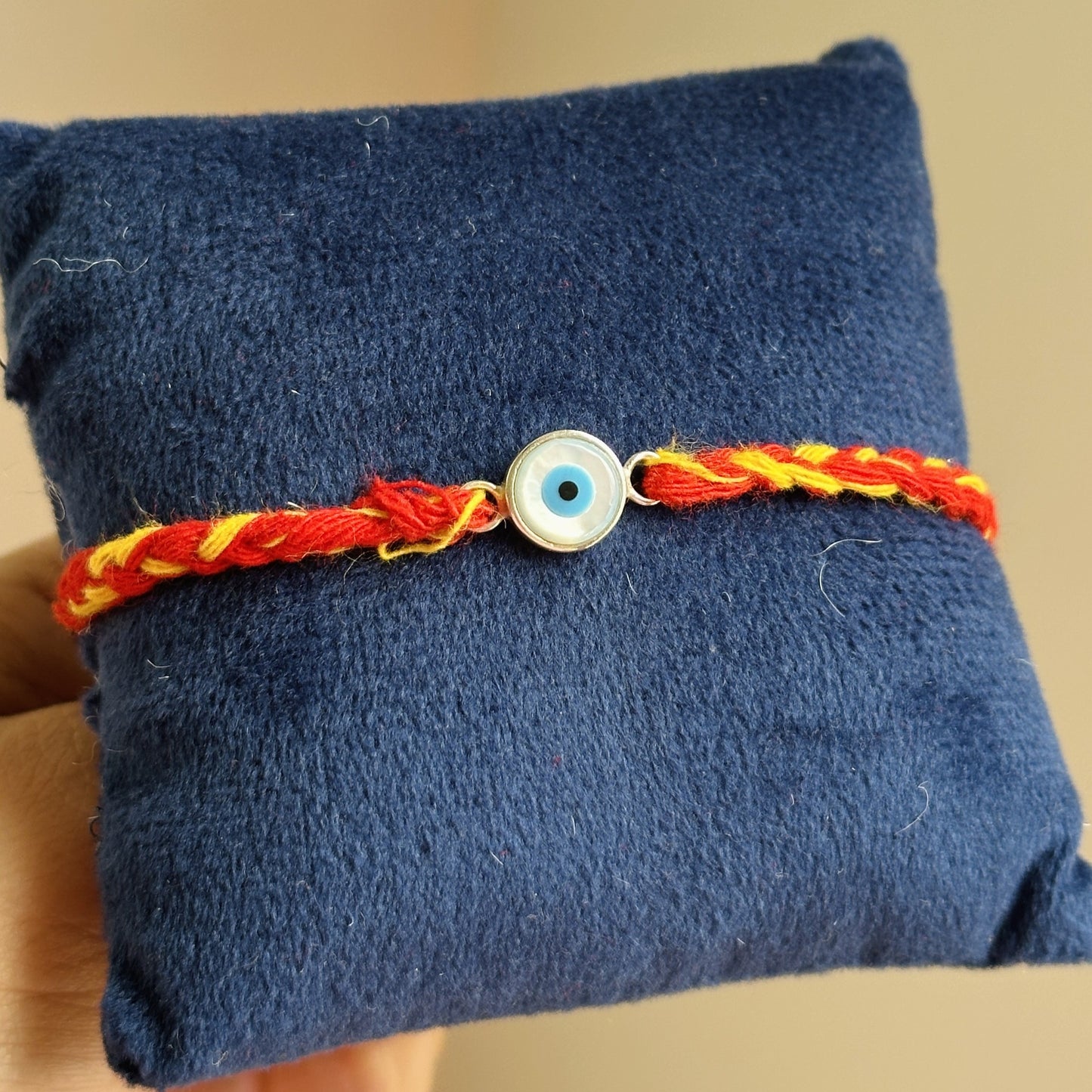 eternal evil eye rakhi 8mm shown with festive raksha bandhan gift box